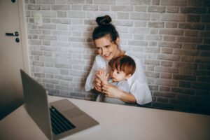 Happy mother and baby bonding during an online video call at home.