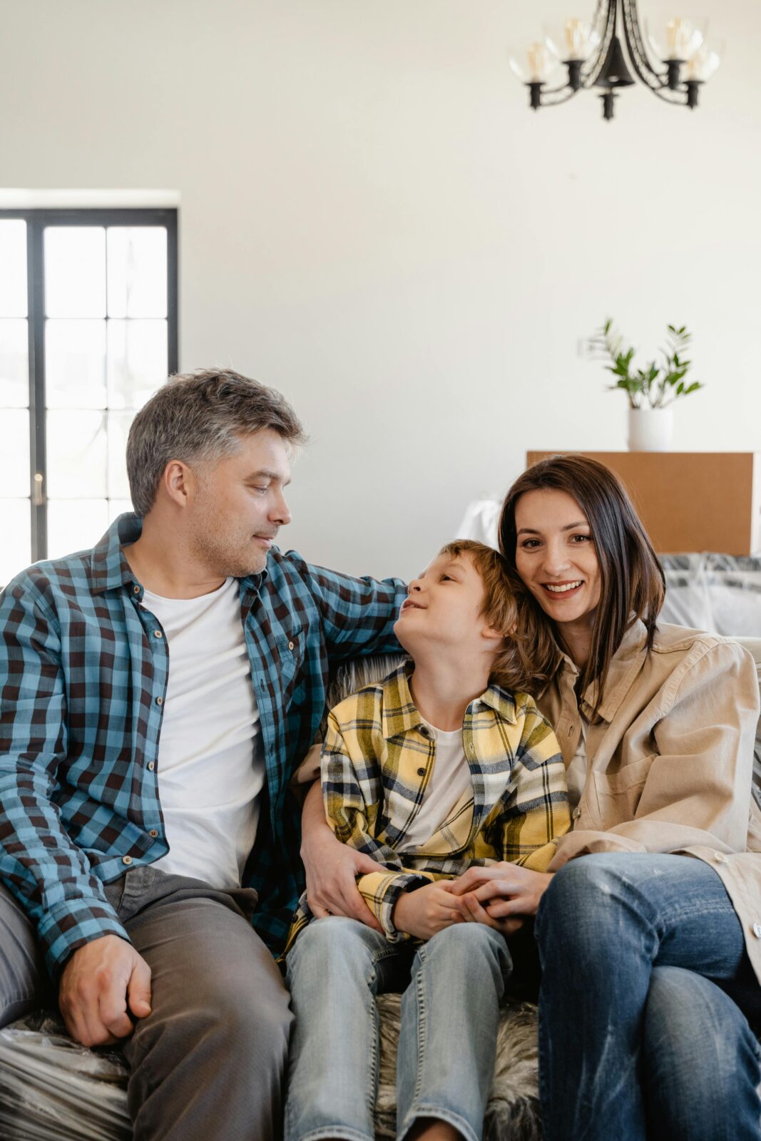 A joyful family sitting together while unpacking in their new home living room.